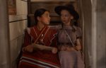 "Two girls sit together on the stairs. "