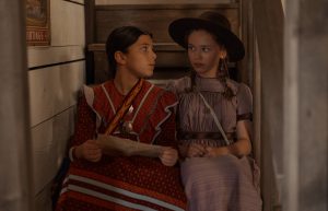 "Two girls sit together on the stairs. "