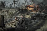 "Two soldiers in dirty uniforms lie on a smoky, war-torn battlefield holding rifles, surrounded by debris and crates, as fire rages behind them and palm trees stand amid destruction."