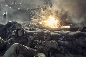 "Two soldiers in combat uniforms take cover behind sandbags as an explosion erupts nearby on a smoky, chaotic battlefield, with flames and debris filling the air."